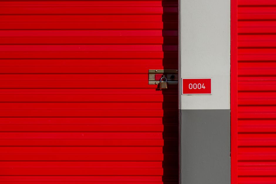 Padlocked red self storage unit door numbered 0004